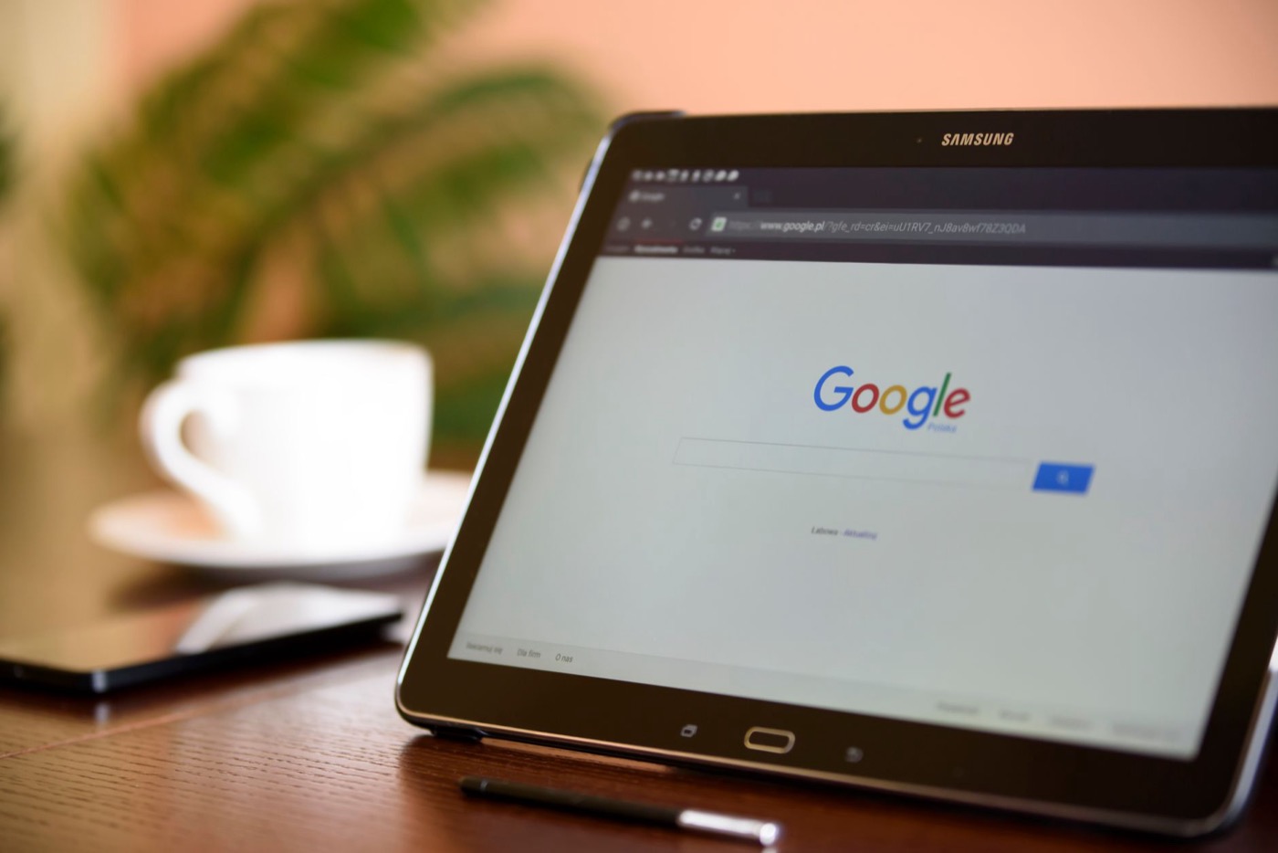 Samsung tablet on desk showing Google homepage.