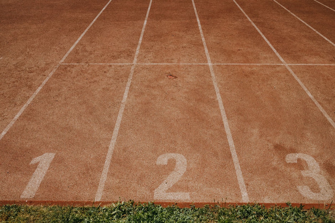 Outdoor sports track with lanes numbered 1 to 3, ready for an athletic event.