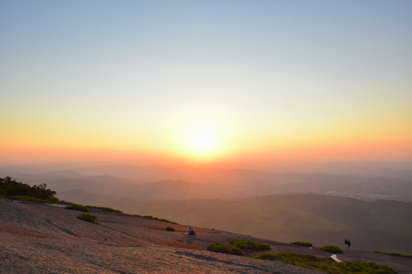 A breathtaking sunrise over a vast mountainous landscape with clear skies.